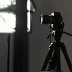 black camera on tripod in grayscale photography