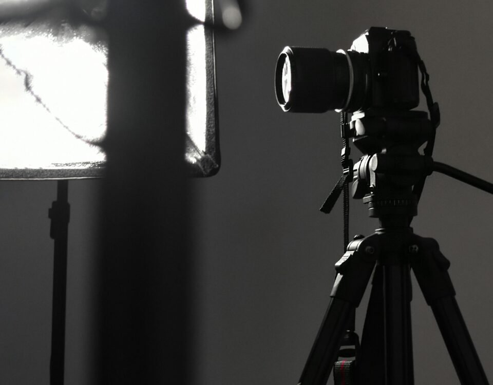 black camera on tripod in grayscale photography